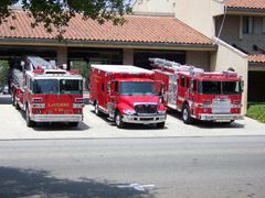 Three Fire Trucks Outside a Station